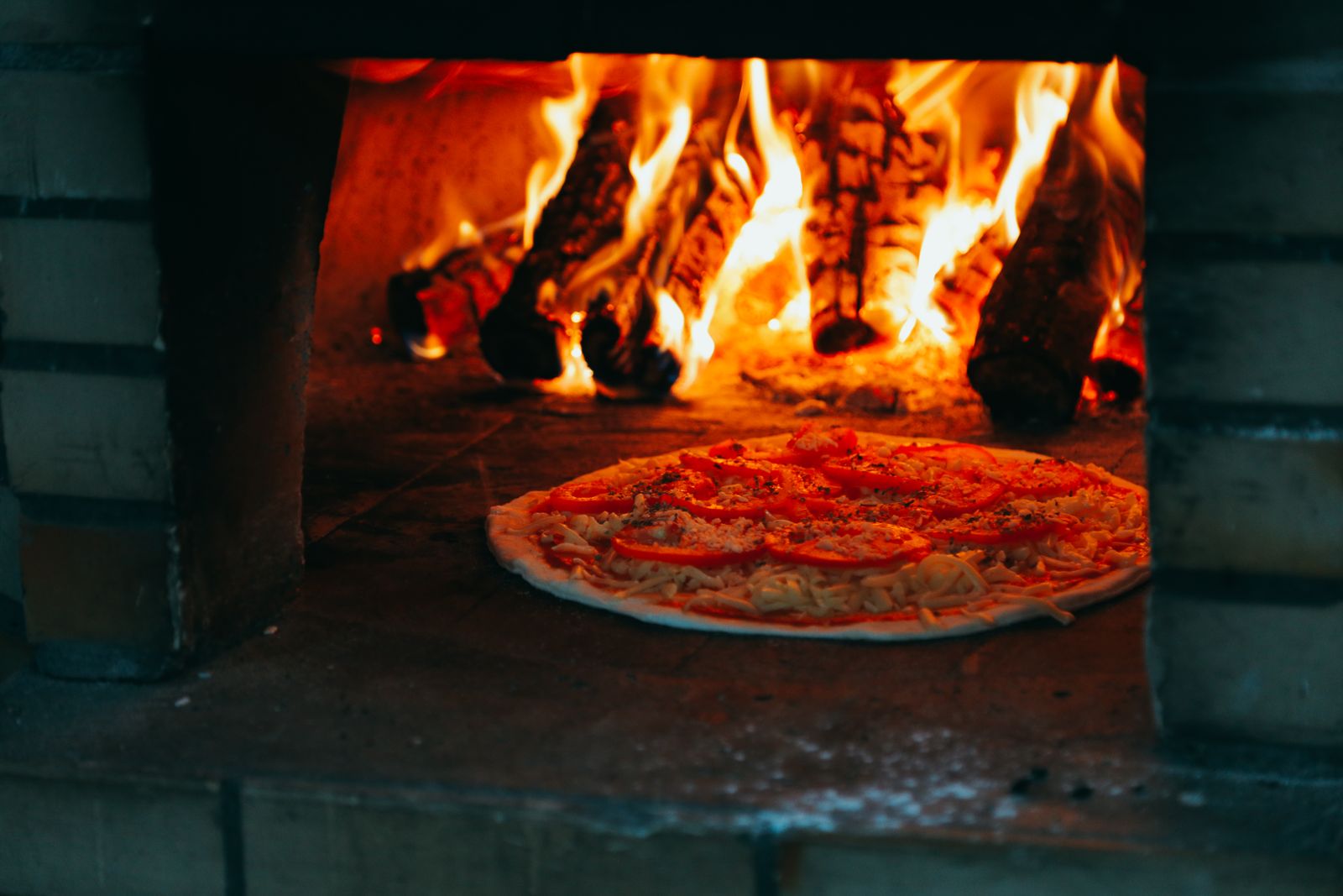 Pizza baking in a wood-fired oven